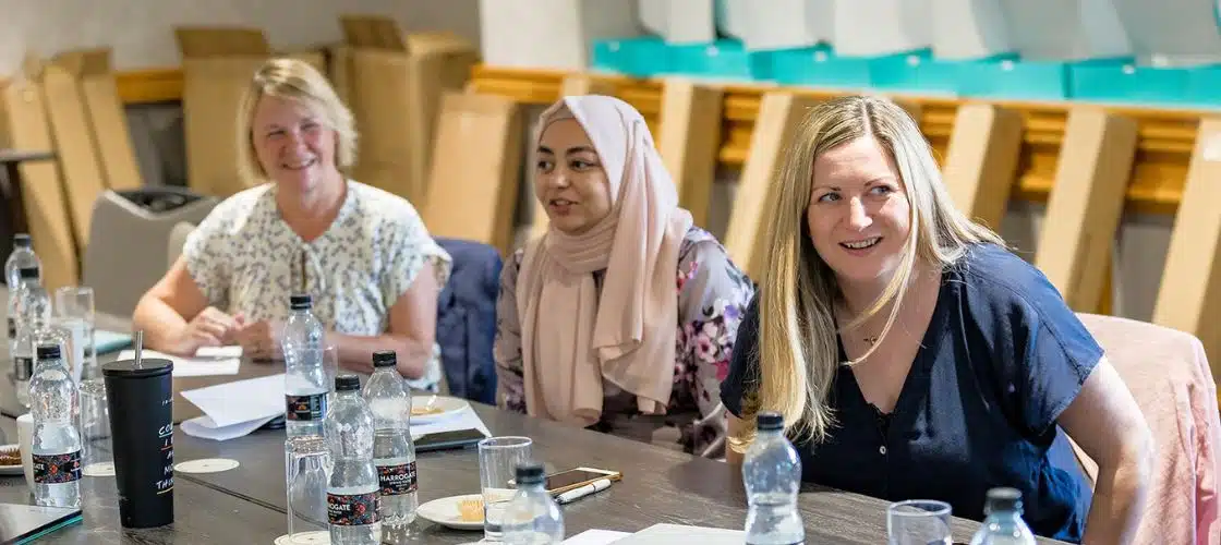 Photo of three women laughing showing our brand values