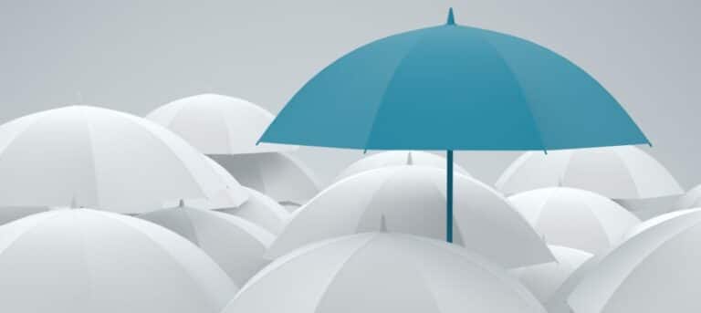 Inage of a single blue umbrella with a number of white umbrellas - HR consultant marketing