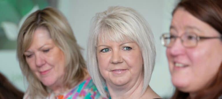 Photo of three women, one showing empathetic face to others - empathy in HR