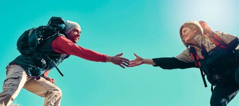 two people reaching across with one helping the other - building trust with HR clients