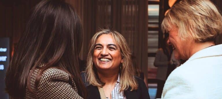 Photo of a woman smiling, talking with others - HR consultancy marketing support