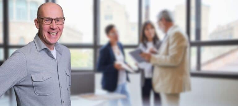 Photo of a man smiling with people in the background - trusted local HR expert